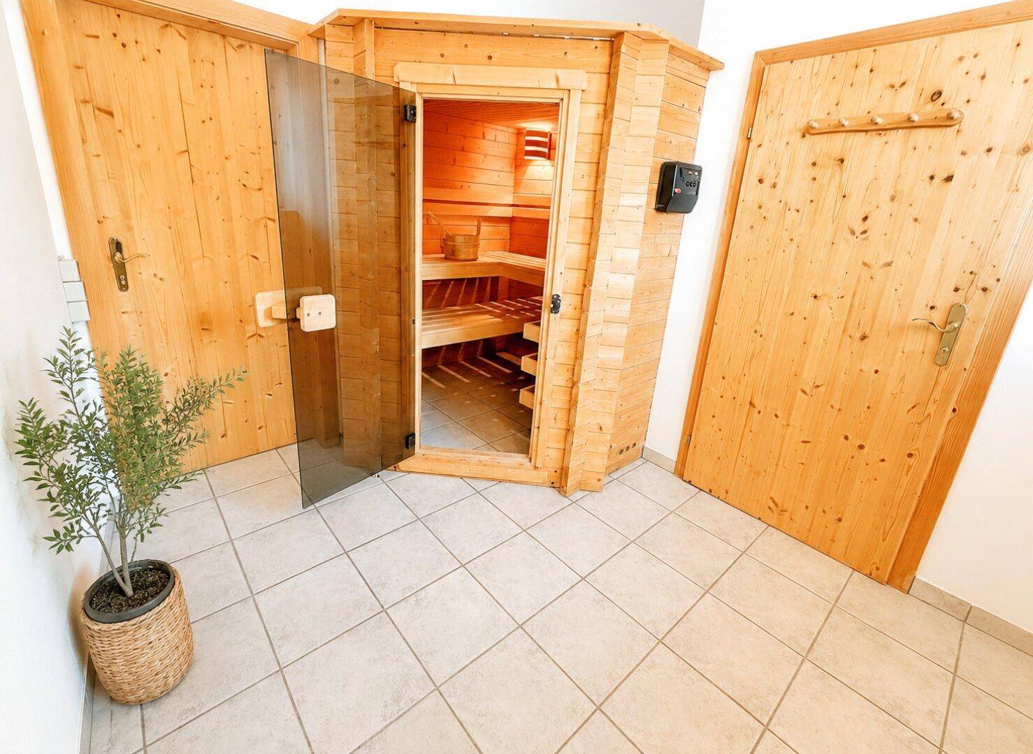 Kleiner Raum mit einer holzvertäfelten Sauna, bereit zur Entspannung und Erholung.