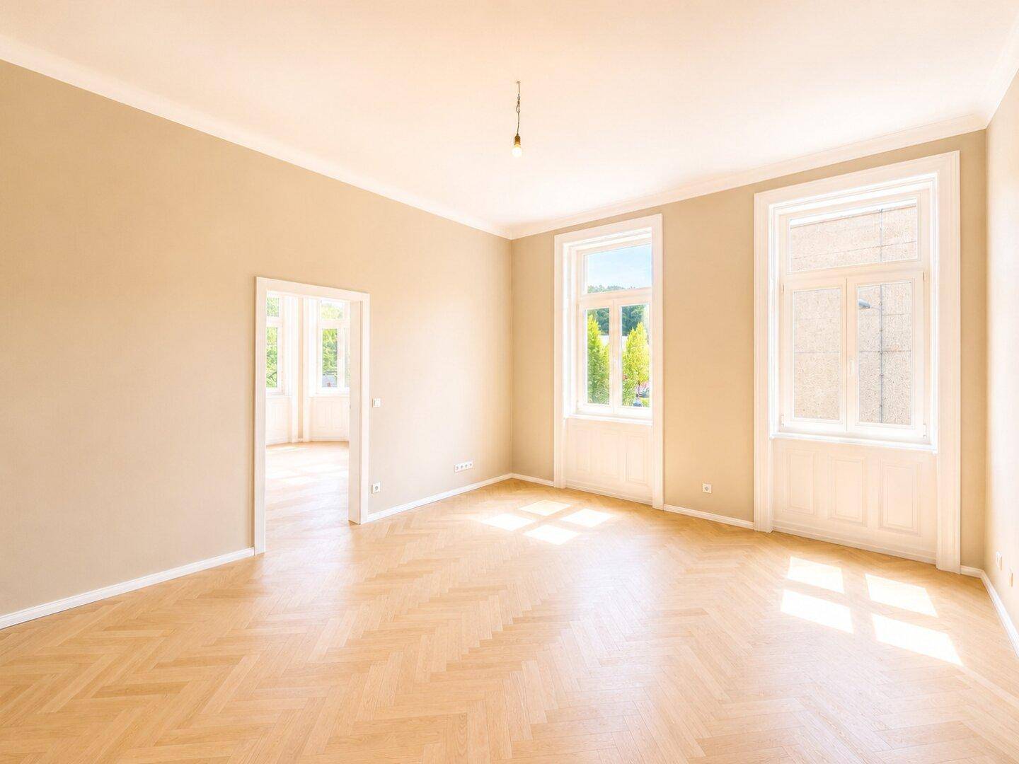 Geräumiges, helles Zimmer mit Fischgrätparkett und hohen Decken, ideal für Wohn- oder Essbereich.