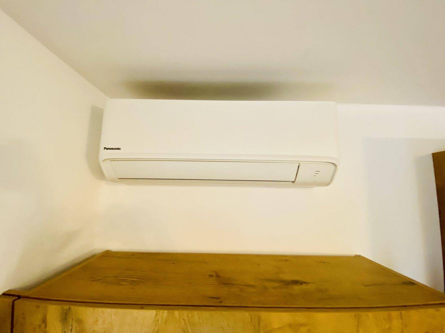 Nahaufnahme einer modernen Klimaanlage an einer weißen Wand.
