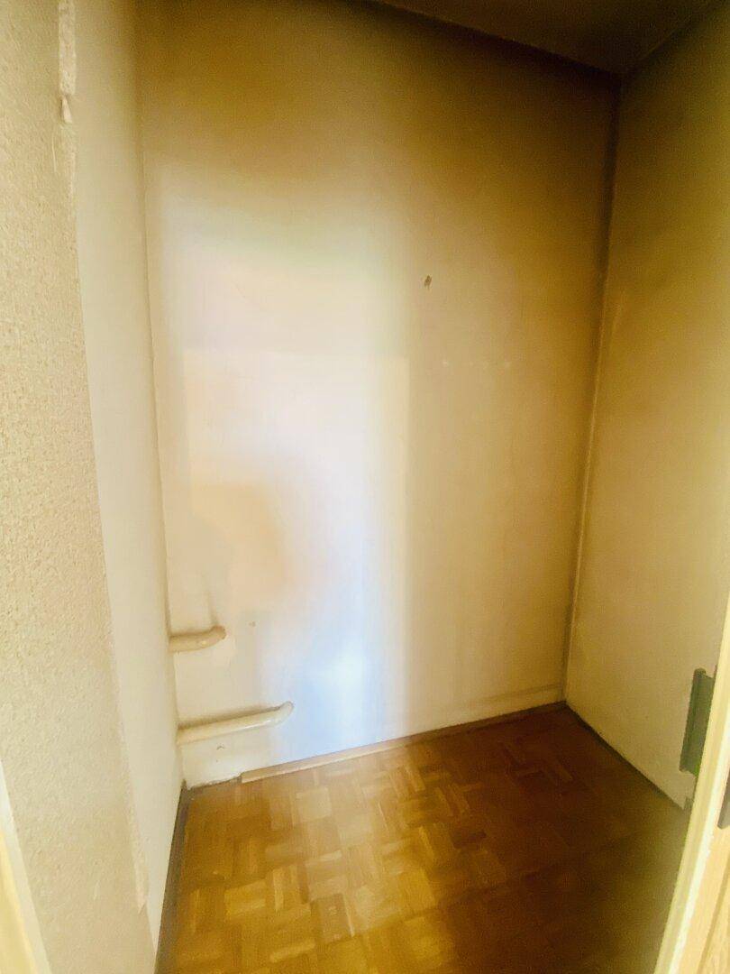 Kleiner Abstellraum mit Fischgrätparkettboden und einfachen Regalen.