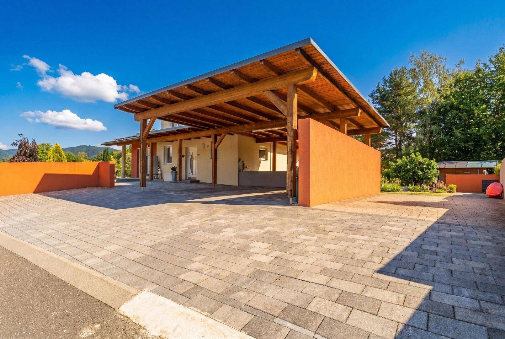 Geräumiger, überdachter Carport mit gepflasterter Einfahrt bietet Schutz für Fahrzeuge.