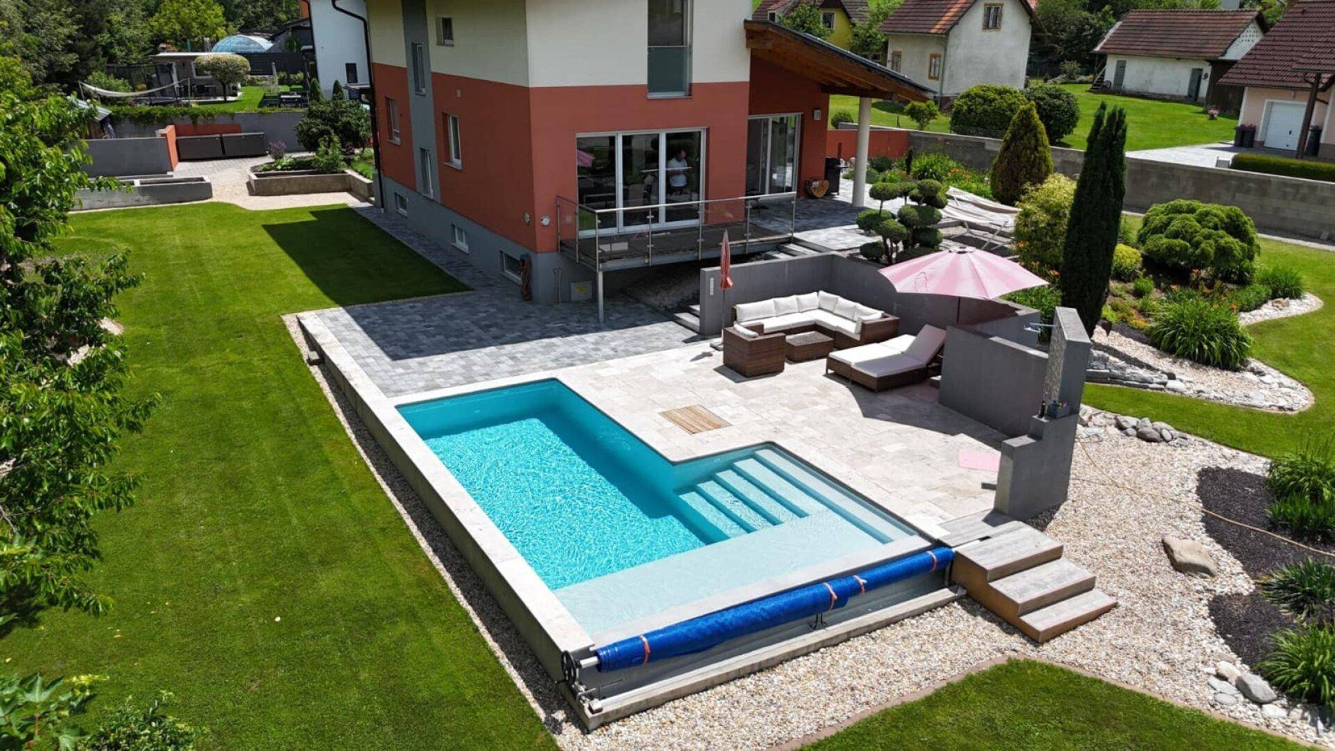 Großzügiger Außenbereich mit modernem Pool, Sonnenterrasse und weitläufigem Rasen.
