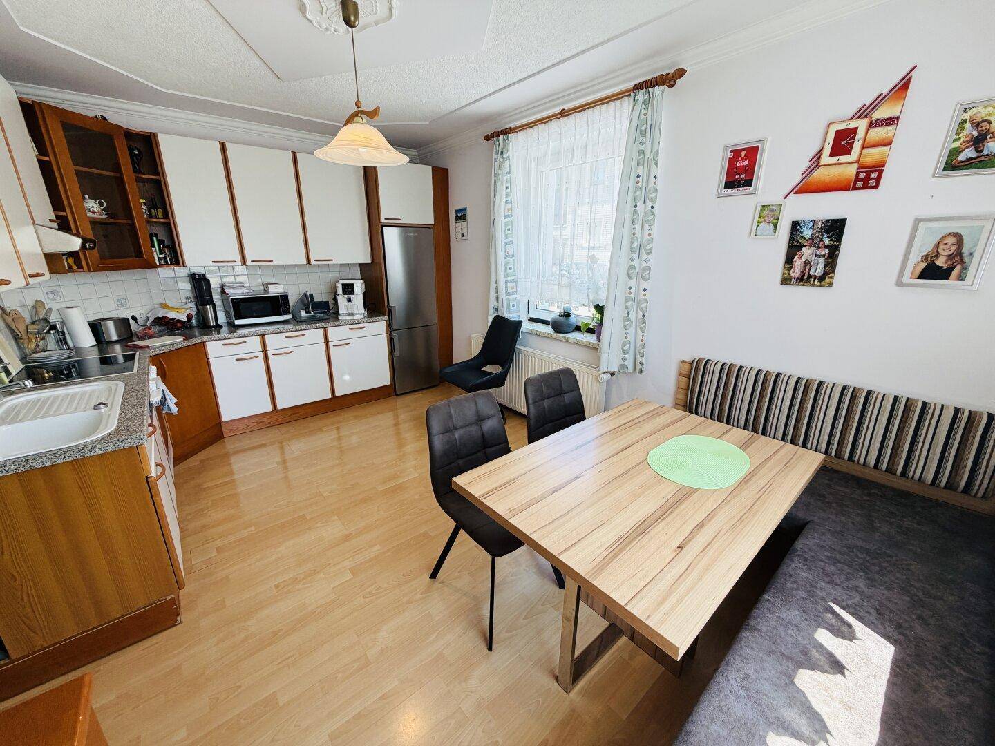 Geräumige Küche mit Essbereich, Holzschränken und modernen Geräten.