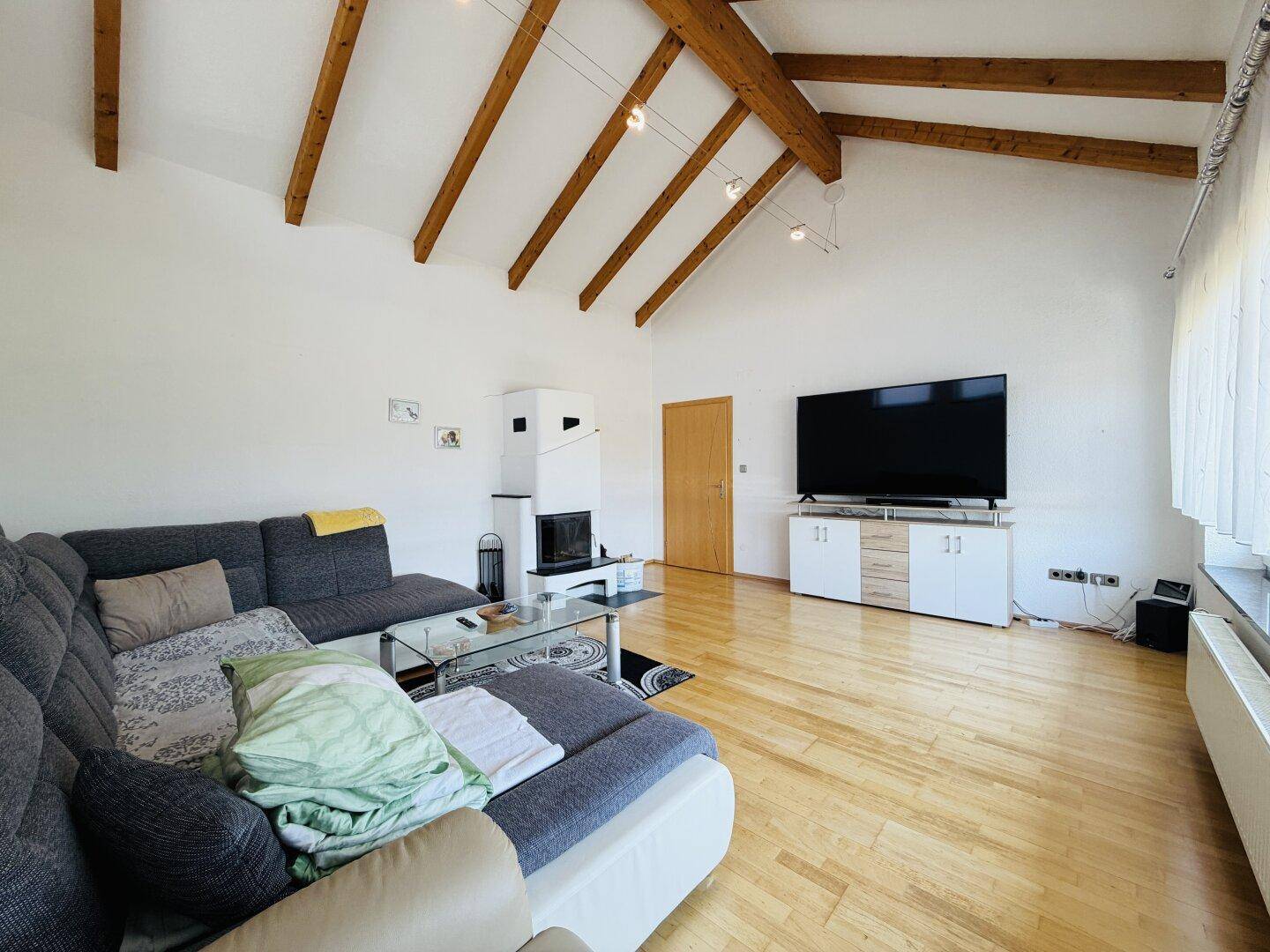 Wohnzimmer mit Kamin, Holzboden und großem Fernseher auf einem modernen Sideboard.