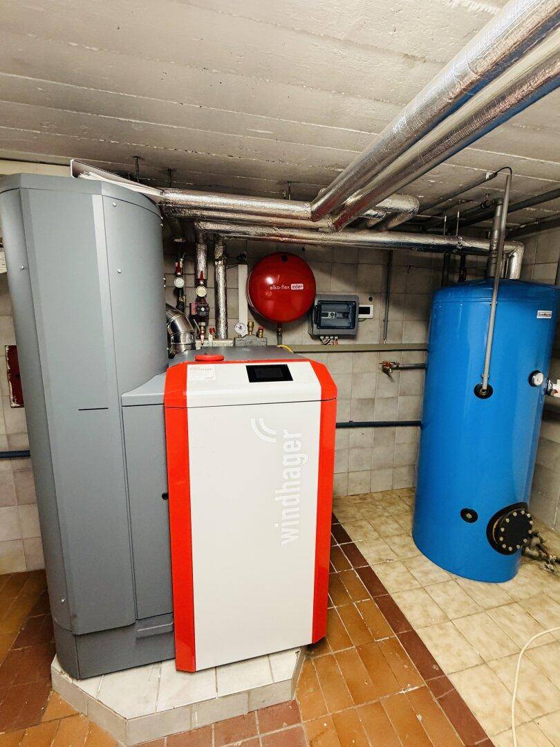 Heizungsraum mit Windhager-Heizsystem und Warmwasserspeicher im Kellerbereich.