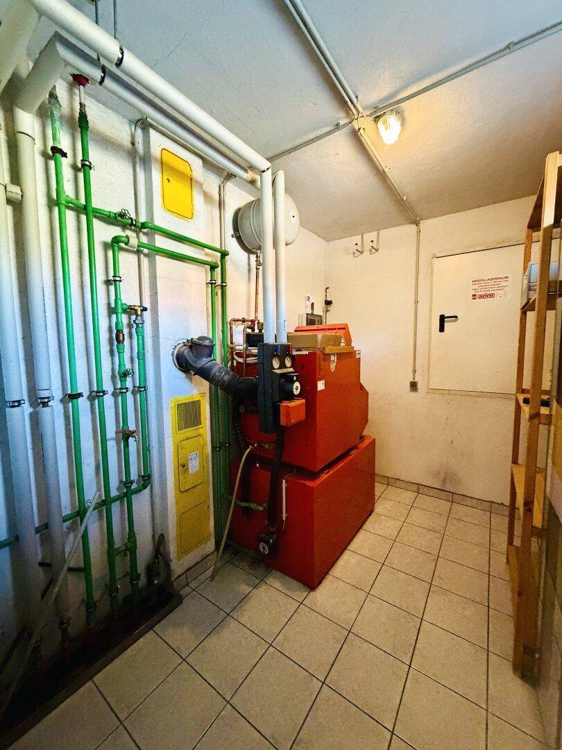 Heizungsraum mit zentraler Heizanlage und sichtbaren Rohrleitungen.