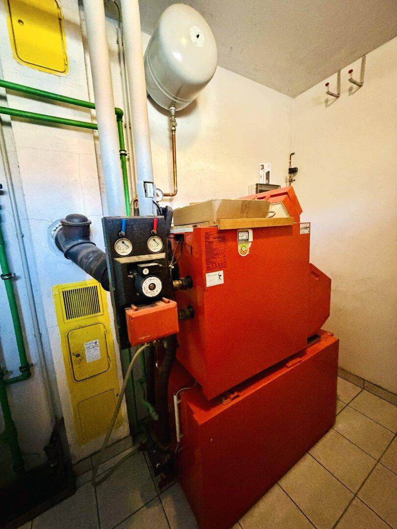 Detailansicht der Heizungsanlage im Technikraum mit Manometern und Leitungen.