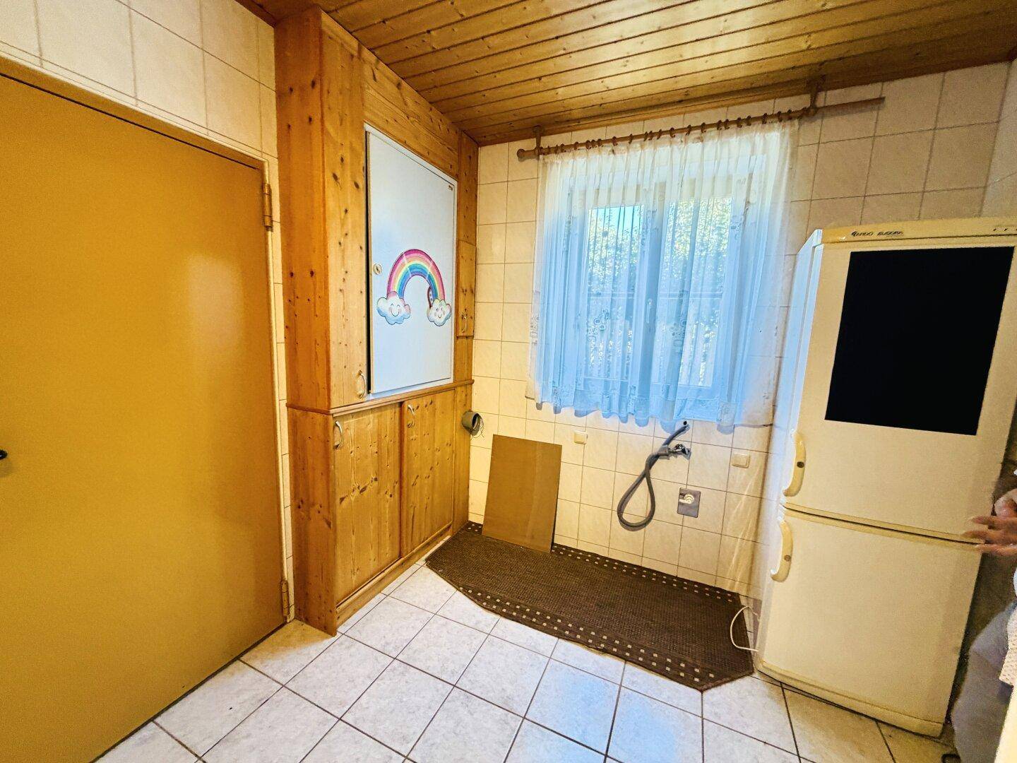 Detailansicht des Hauswirtschaftsraums mit Fenster und Anschlüssen für Haushaltsgeräte.