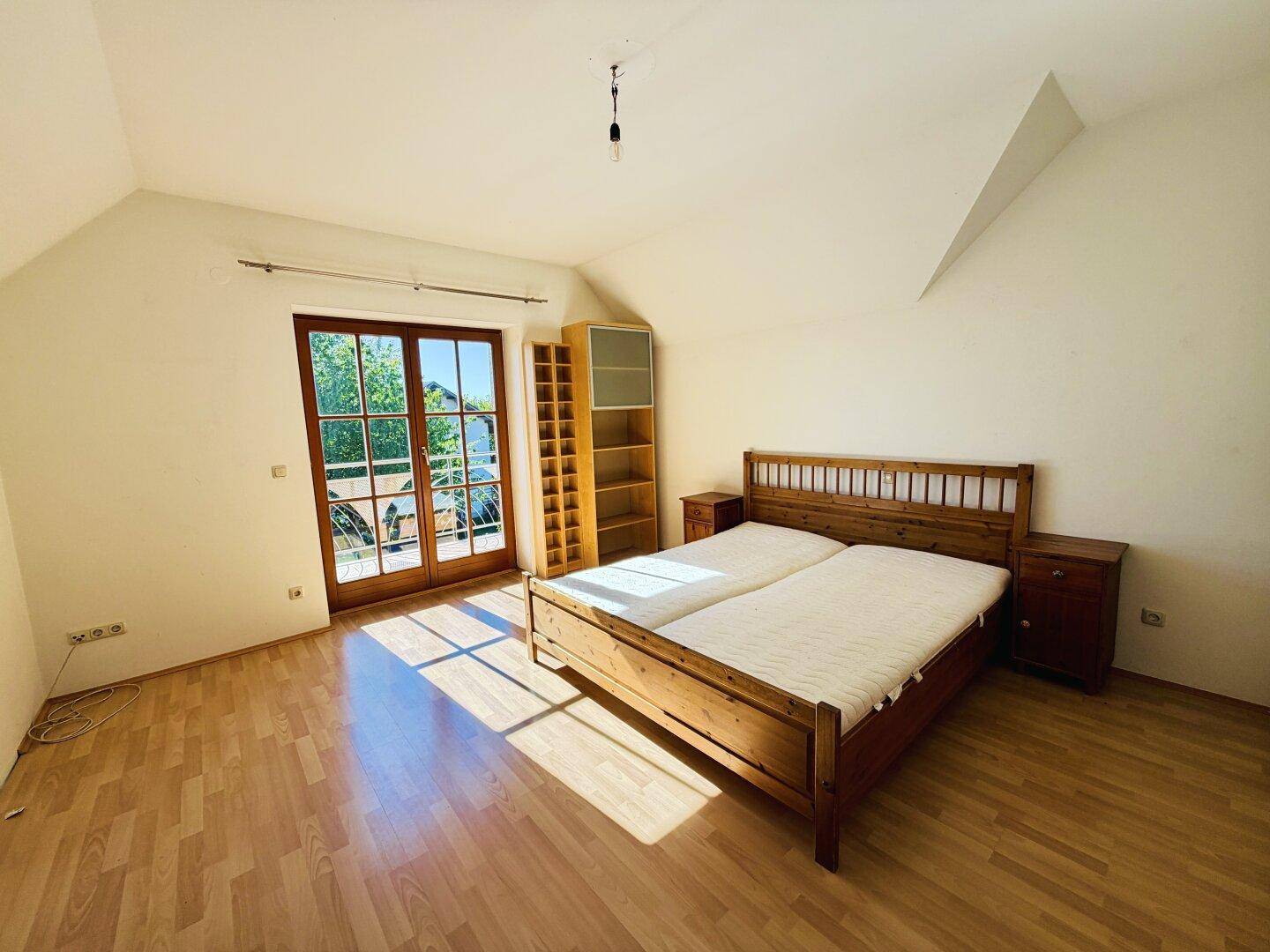 Gemütliches Schlafzimmer mit Holzbett und Nachttischen, bietet direkten Zugang zum Außenbereich.