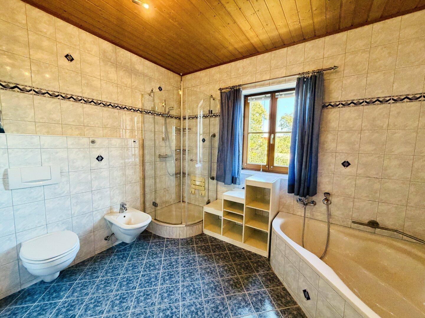 Badezimmer mit Badewanne, Dusche, WC, Bidet und Fenster, alles in einem traditionellen Stil.