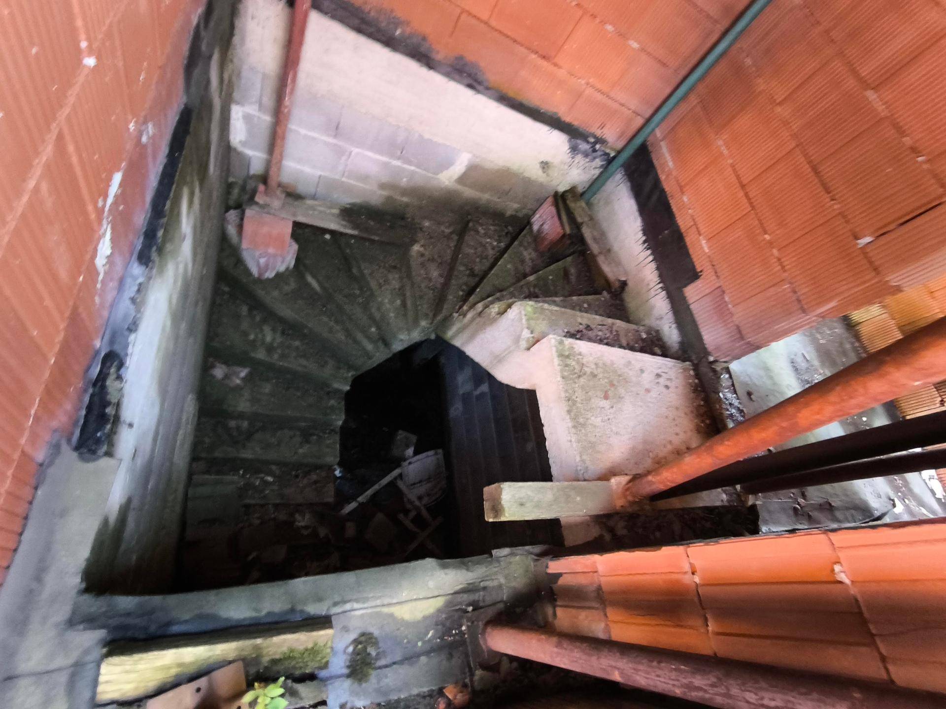 Unfertige Wendeltreppe im Rohbau, die verschiedene Ebenen des Hauses verbindet.
