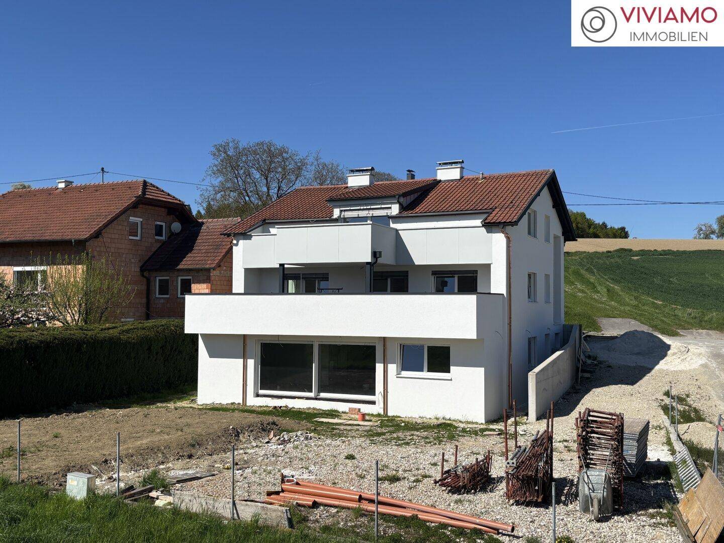 Ansicht der modernen Doppelhaushälfte mit Balkonen und Terrassen im Bauzustand.