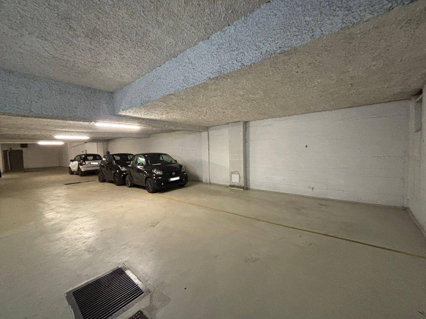 Tiefgarage mit mehreren Stellplätzen und Betonwänden.