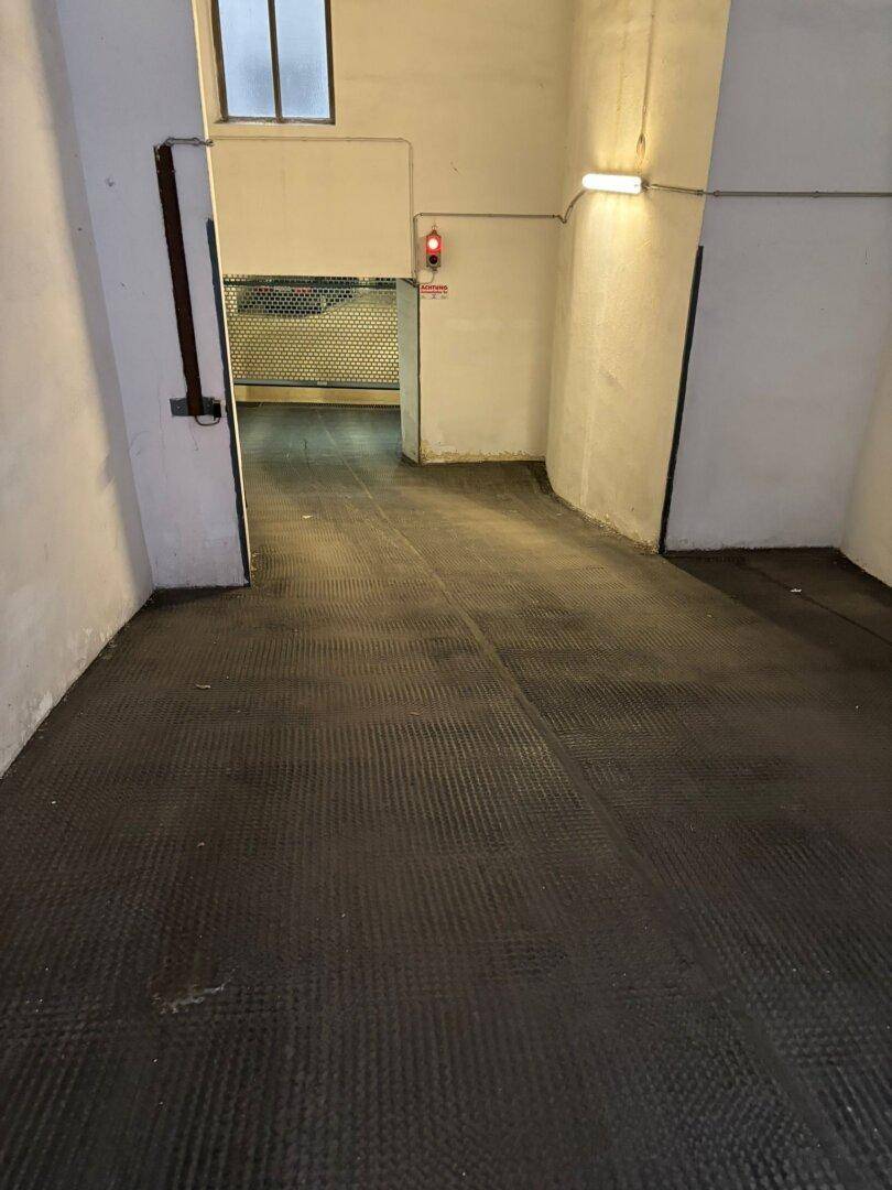 Einfahrt zur Tiefgarage mit rutschfestem Boden und Rolltor.