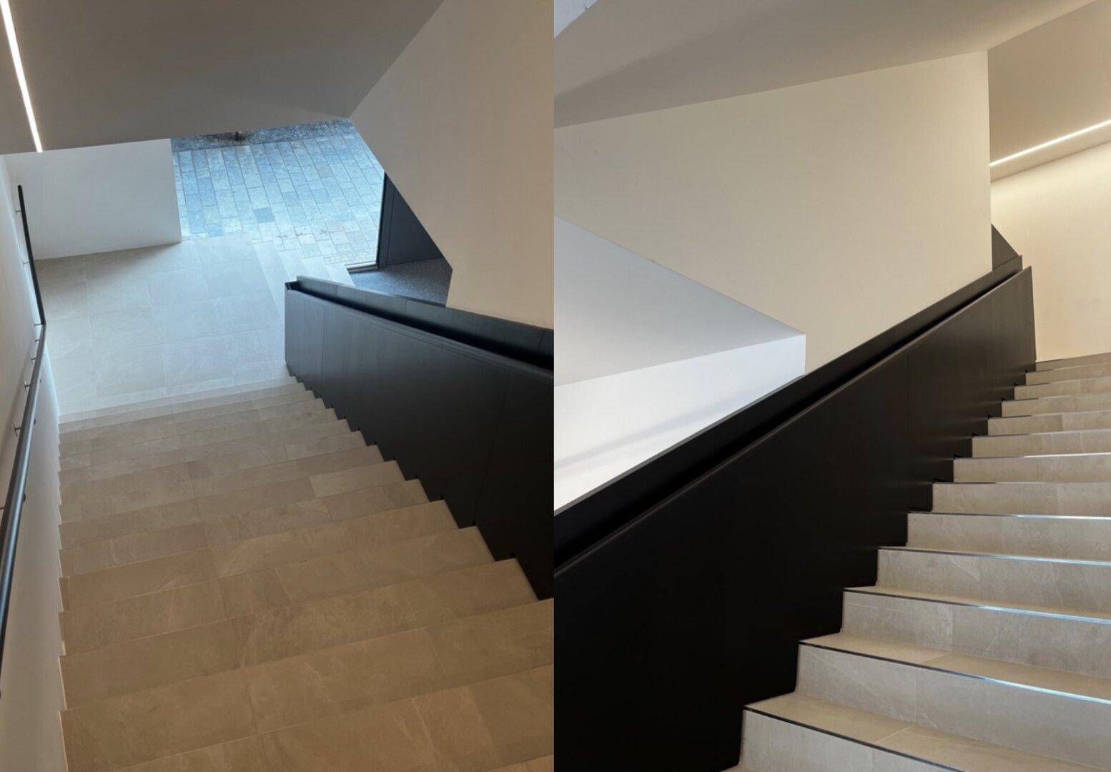 Modernes Treppenhaus mit hellen Stufen, dunklem Geländer und minimalistischem Design.