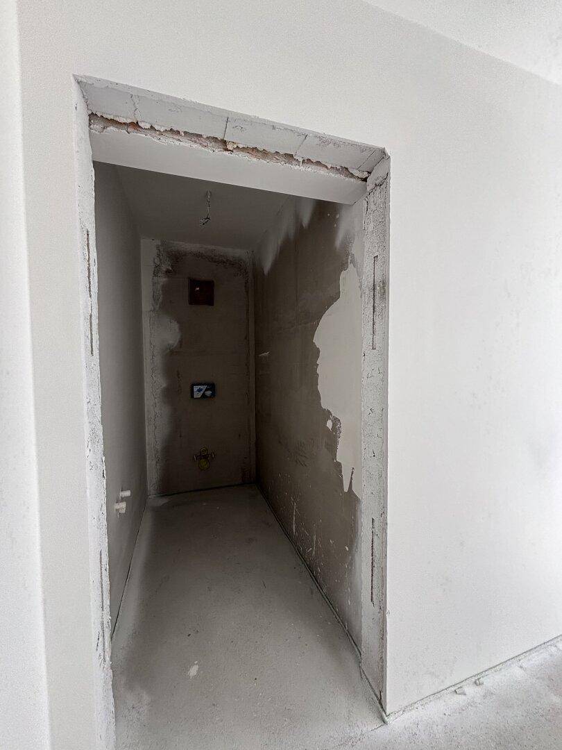 Schmaler Raum im Rohbau, ideal als Abstellraum oder für technische Installationen.