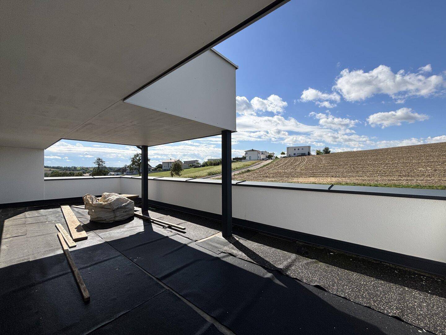 Großer, noch unfertiger Balkon mit weitem Blick über die umliegende grüne Landschaft.
