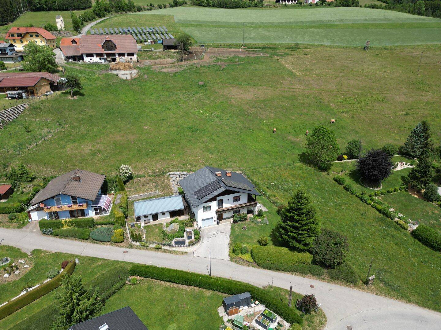 Weitläufige Luftaufnahme des Anwesens mit Haus, Garten und der umliegenden ländlichen Landschaft.
