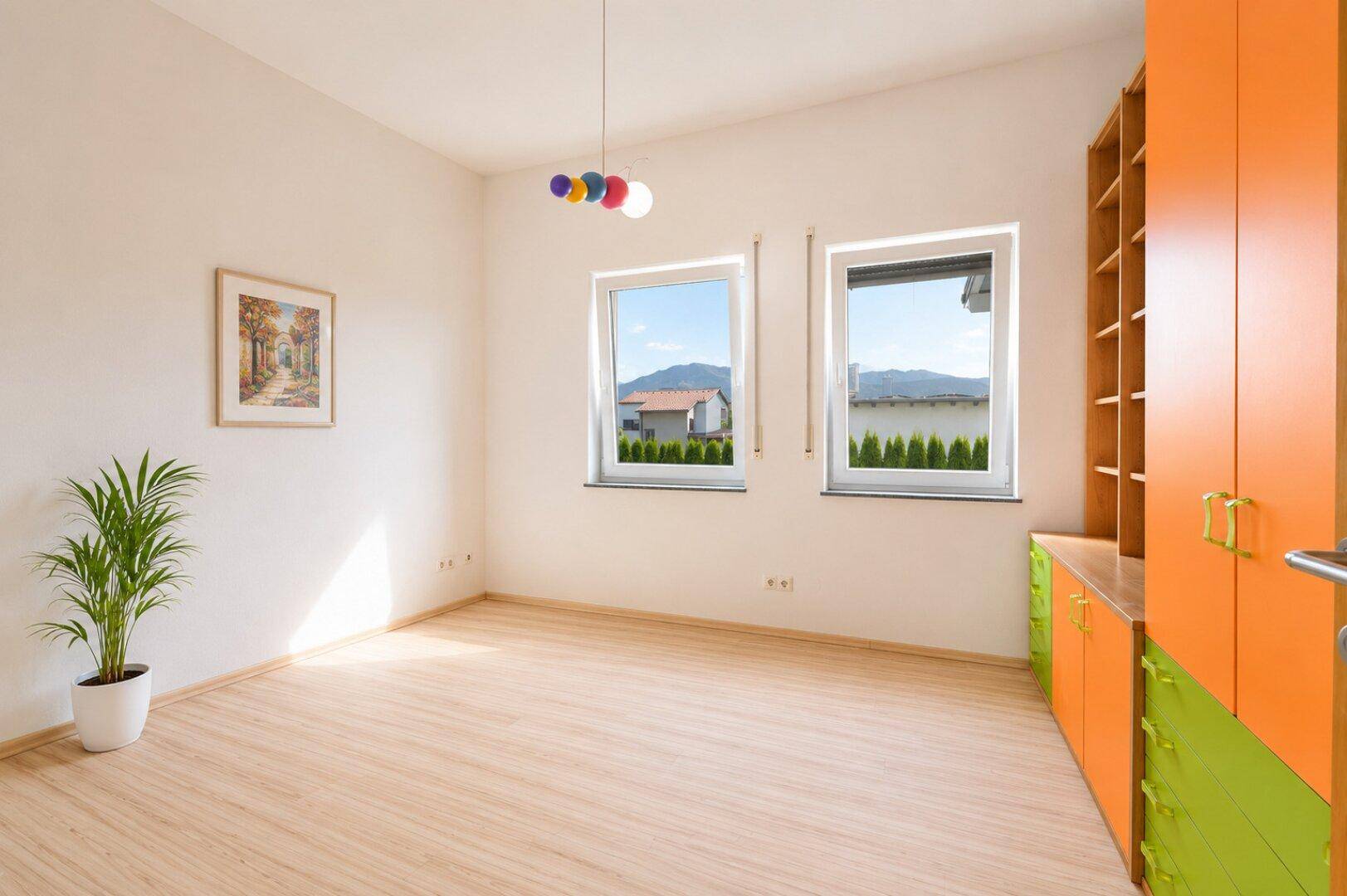 Helles Zimmer mit hellem Holzboden und farbenfrohen Einbauschränken.
