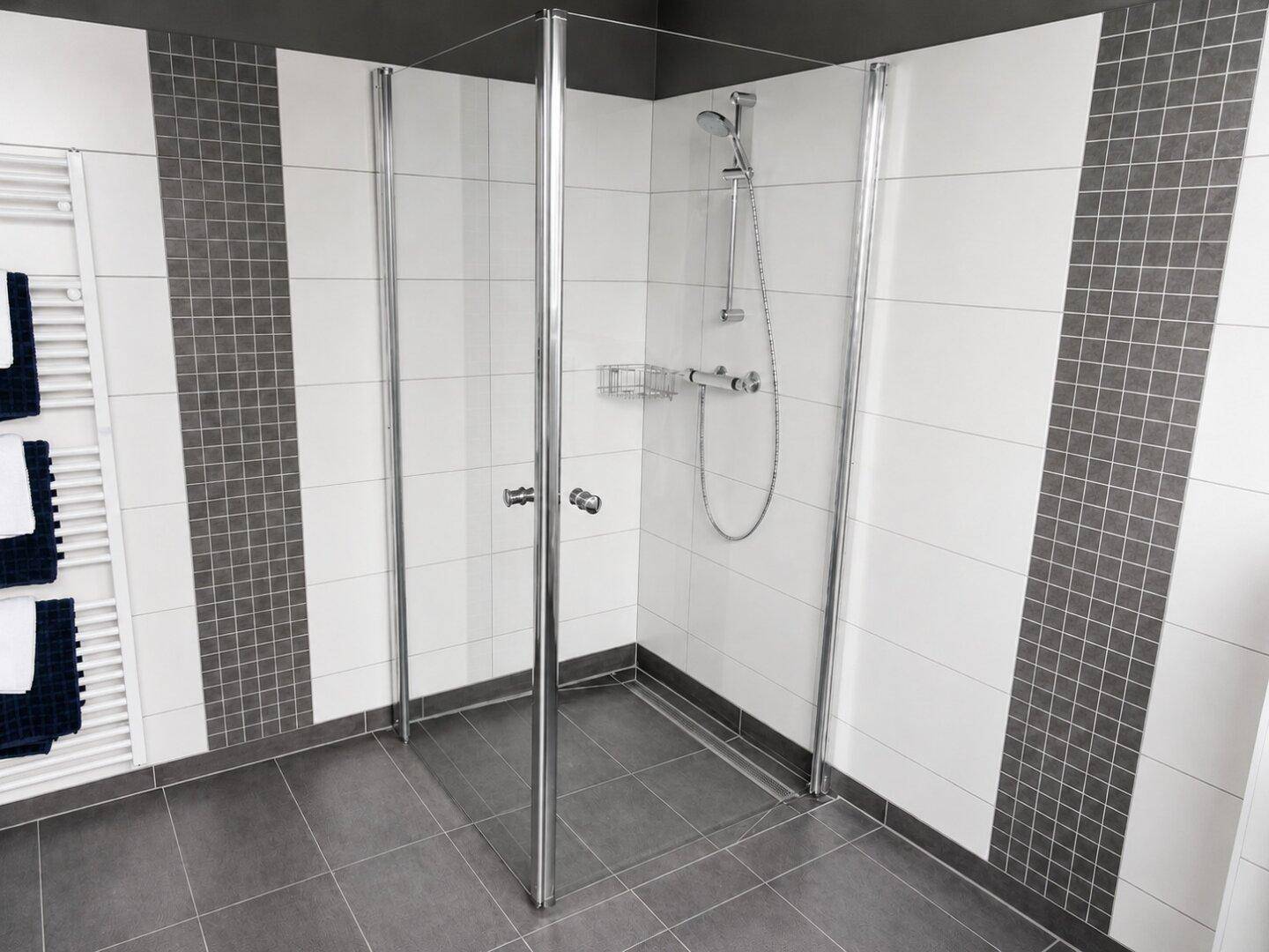 Modernes Badezimmer mit begehbarer Dusche, weißen und grauen Fliesen sowie einem Handtuchheizkörper.