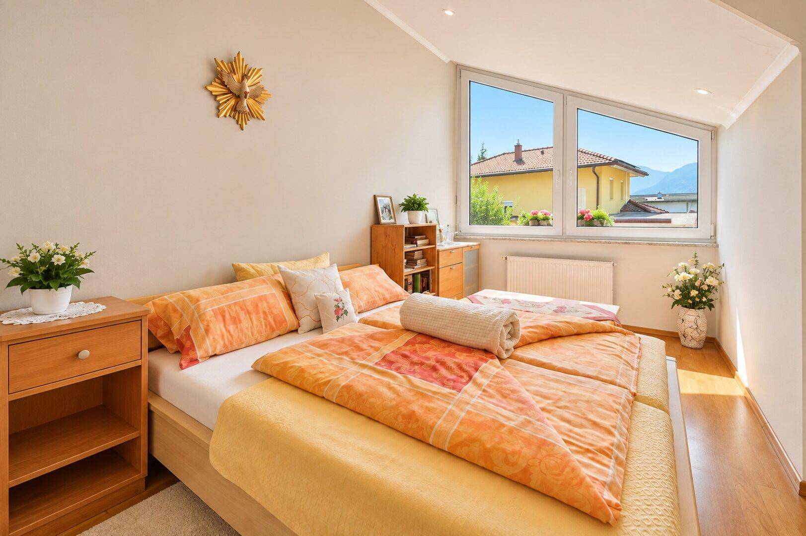 Helles Schlafzimmer mit zwei Einzelbetten, Holzboden und großen Fenstern mit Blick auf die Umgebung.