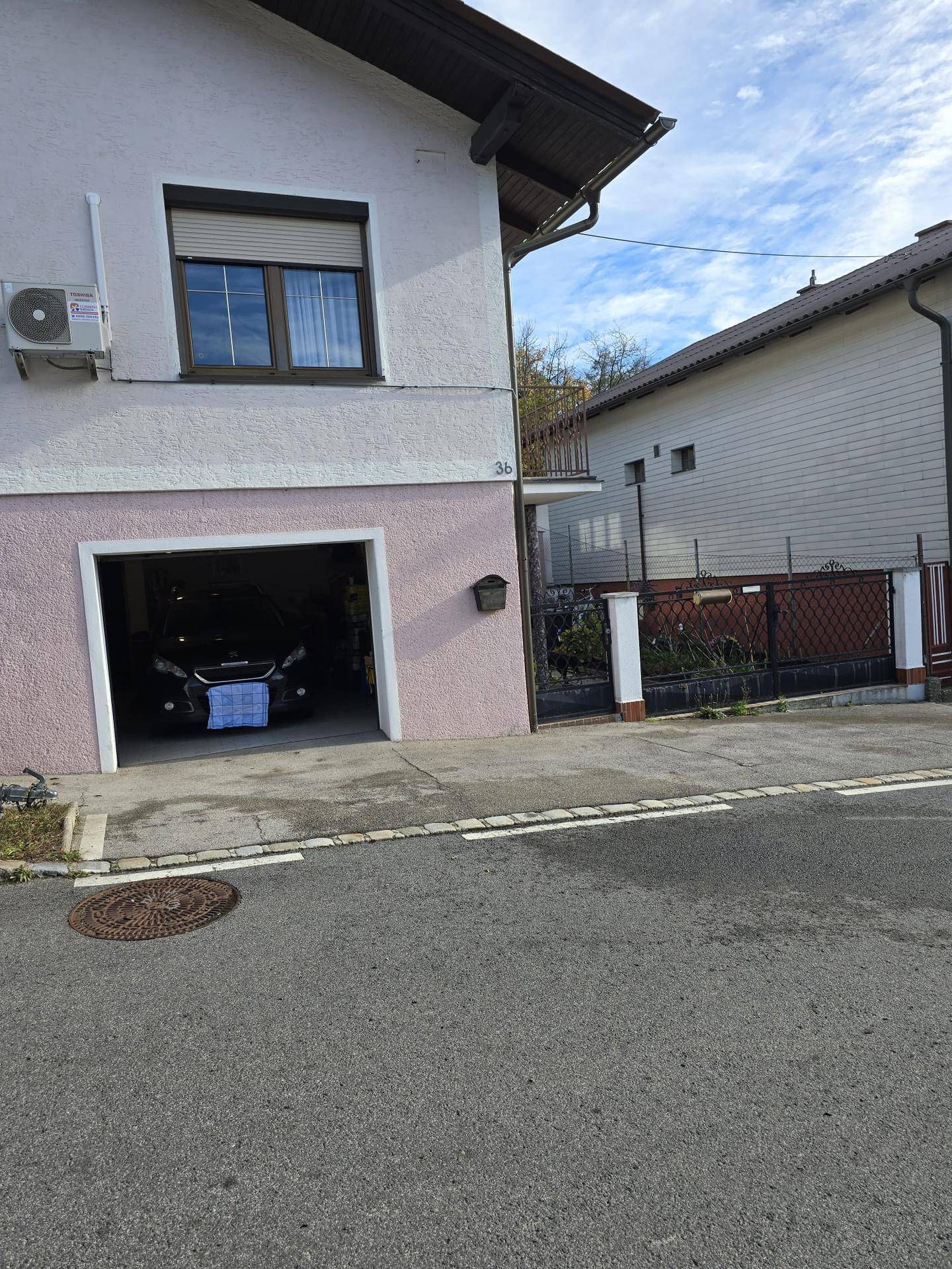 Außenansicht eines Hauses mit Garage, Einfahrt und Blick auf die Straße.