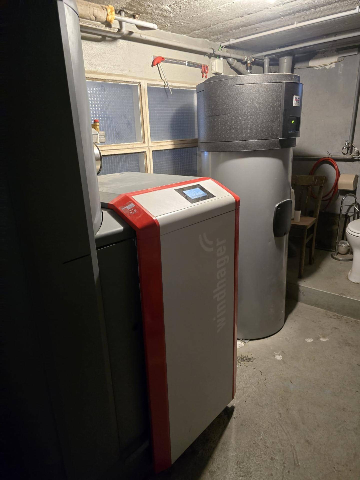 Heizungsraum mit modernen Heizungsanlagen und einem Warmwasserspeicher für das Gebäude.