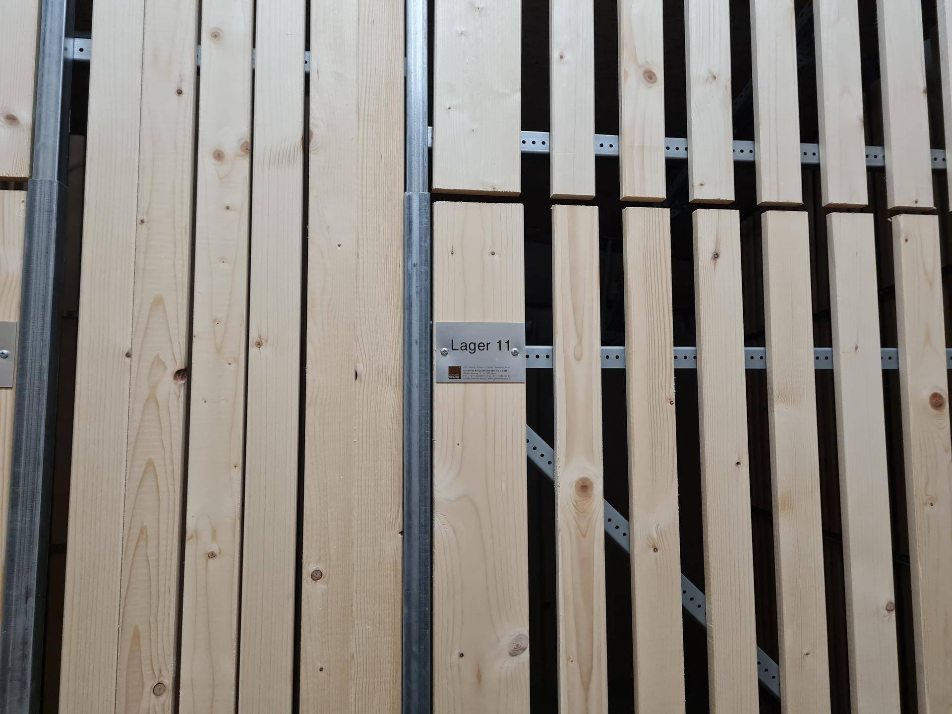 Holzlattenwände eines Lagerraums mit einer Beschriftung, die auf die Lagereinheit 11 hinweist.