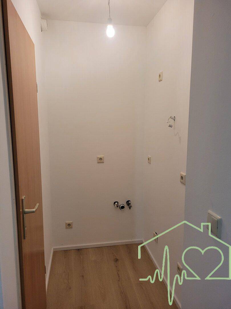 Kleiner Hauswirtschaftsraum mit Anschlüssen für Waschmaschine und Trockner, ideal als Abstellraum.