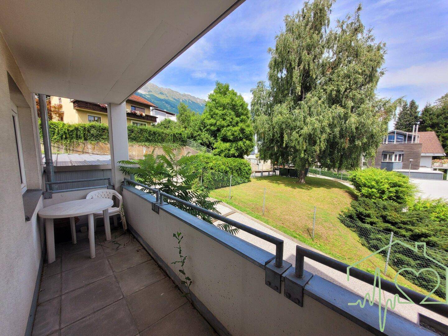 Gemütlicher Balkon mit Sitzgelegenheiten und weitem Blick auf die grüne Umgebung und Berge.