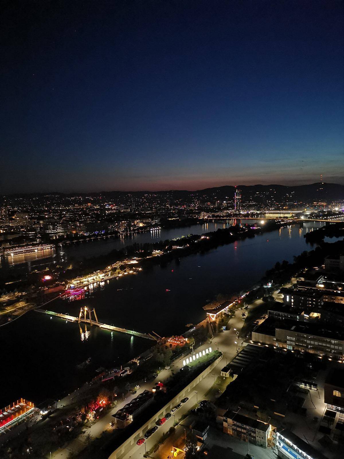 Beeindruckender Nachtblick über die Stadt und den Fluss mit beleuchteten Brücken und Gebäuden.