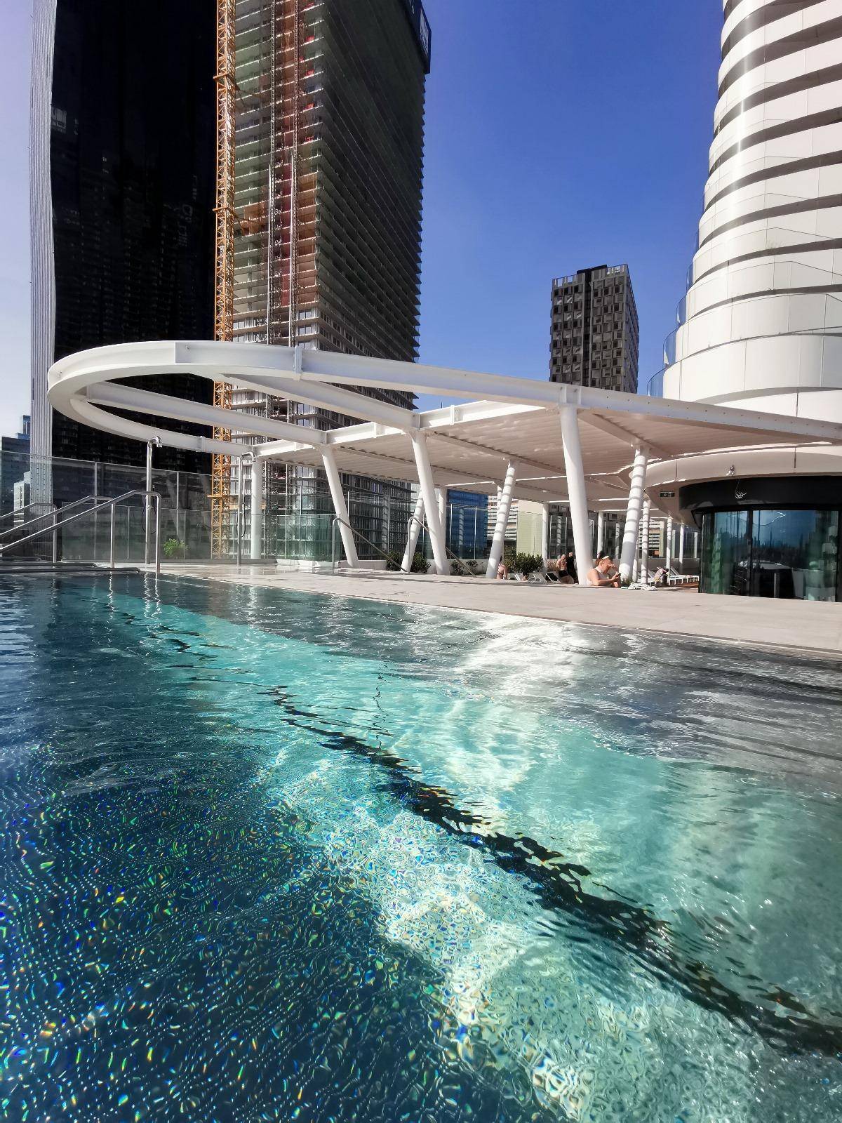 Außenpoolbereich mit moderner Architektur und umliegenden Hochhäusern.