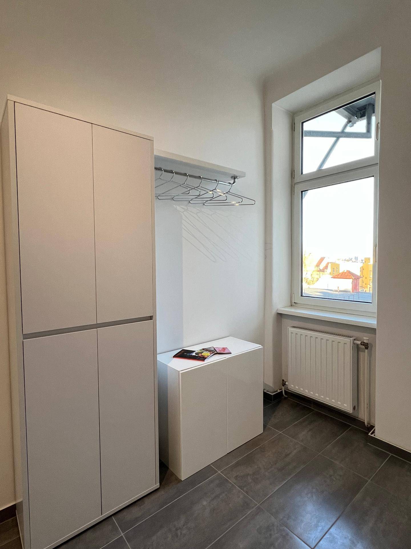 Eingangsbereich mit praktischem Kleiderschrank, Garderobe und Fenster für Tageslicht.
