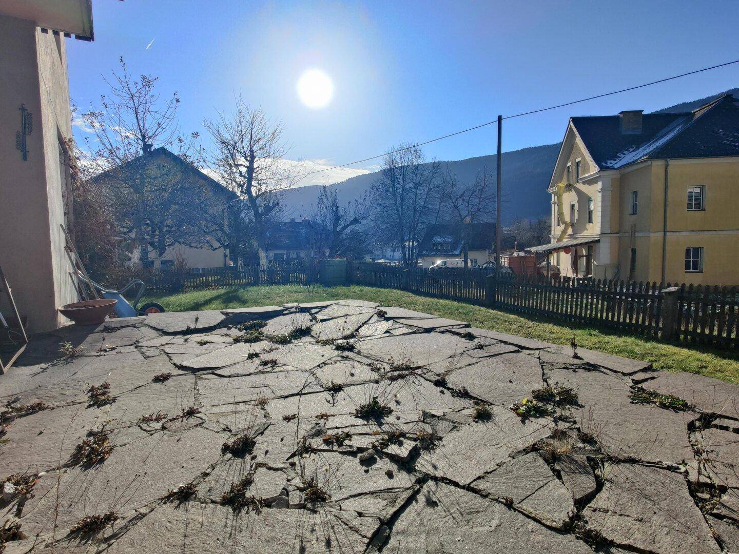Gepflasterte Terrasse mit Blick auf die umliegende Landschaft und sonnigem Himmel.