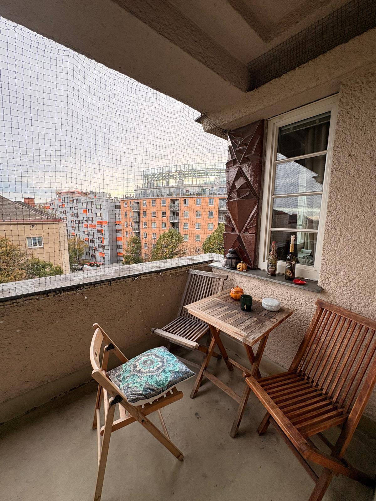 Geräumiger Balkon mit Sitzgelegenheiten und Sicherheitsnetz, ideal für entspannte Stunden im Freien.