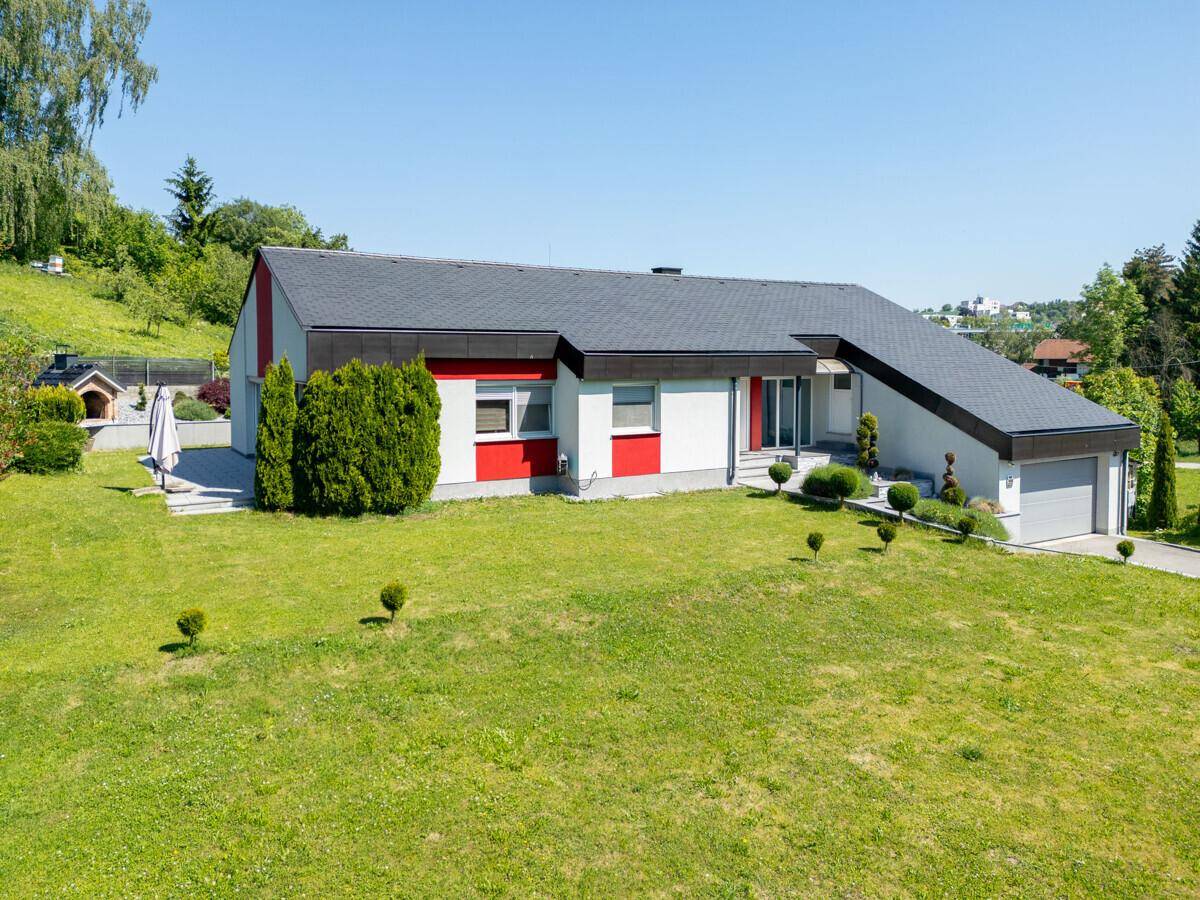 Vorderansicht des Hauses mit gepflegtem Rasen, Auffahrt und Garage.