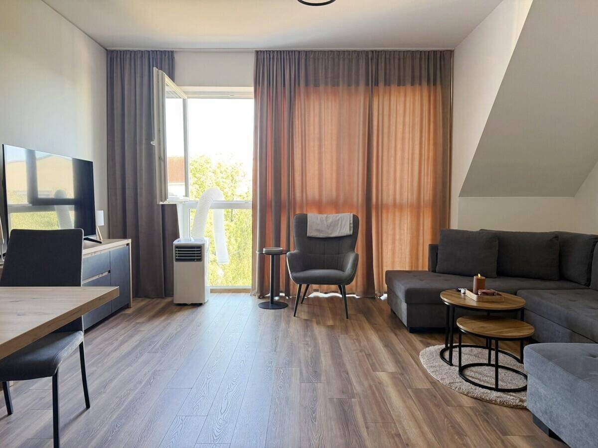 Gemütlicher Wohn- und Essbereich mit Laminatboden, Sofa und Esstisch.