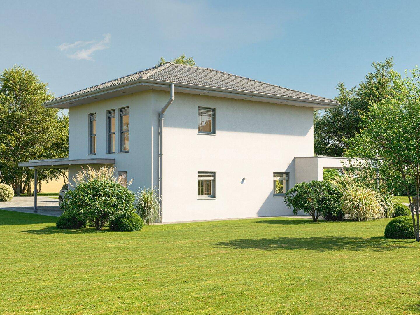 Seitenansicht des modernen Einfamilienhauses mit gepflegtem Rasen und grüner Bepflanzung rund um das Gebäude.