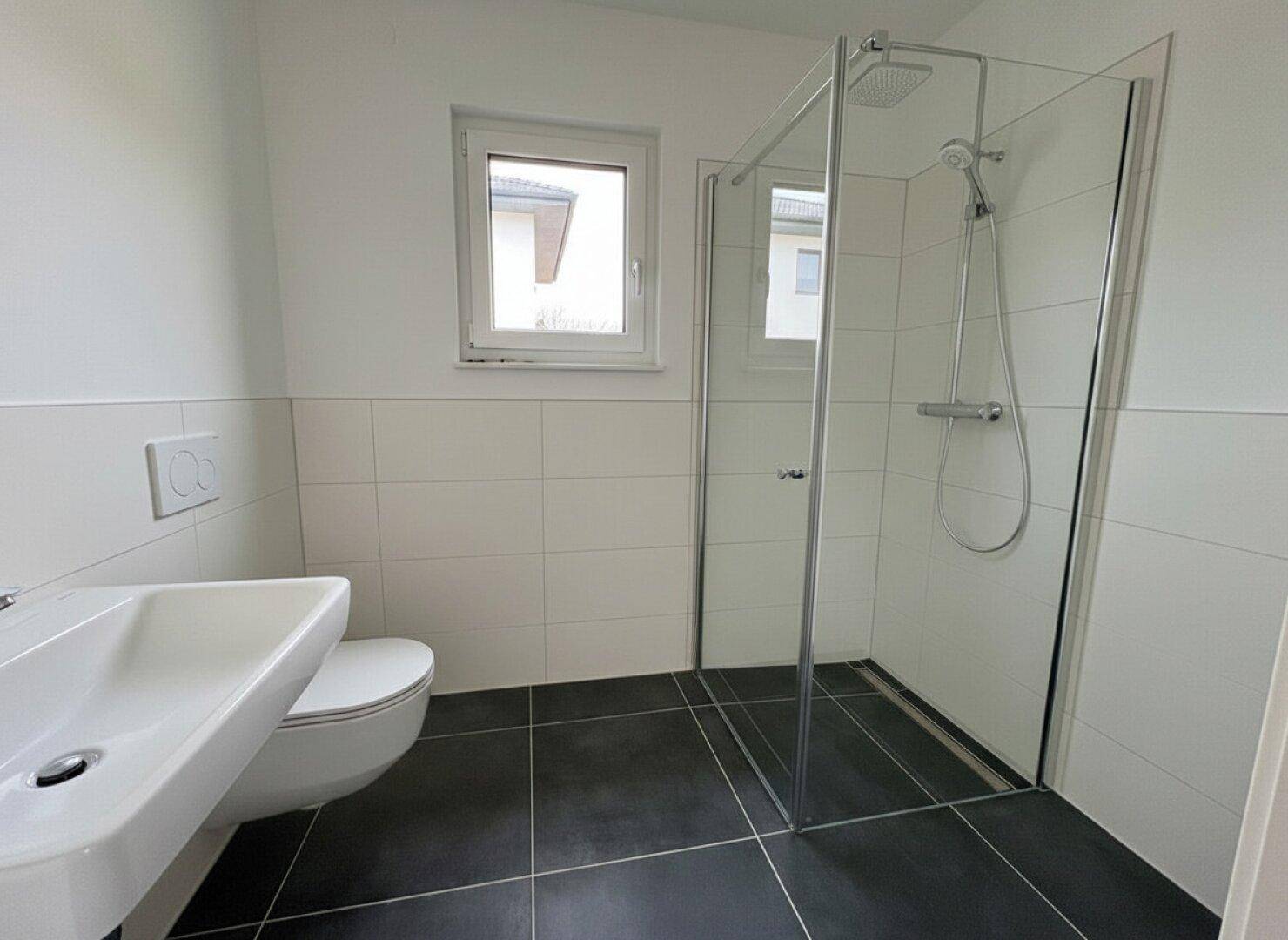 Modernes Badezimmer mit begehbarer Dusche, Wand-WC und Fenster für Tageslicht.