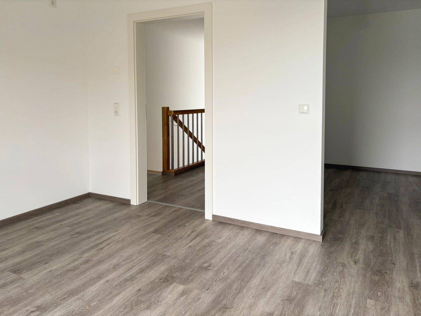 Heller Flur im Obergeschoss mit Laminatboden und Blick auf die Treppe.