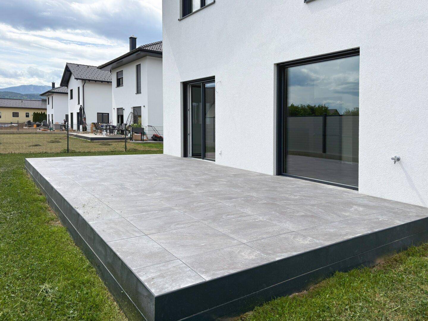 Geräumige, erhöhte Terrasse mit großen Schiebetüren zum Wohnbereich.