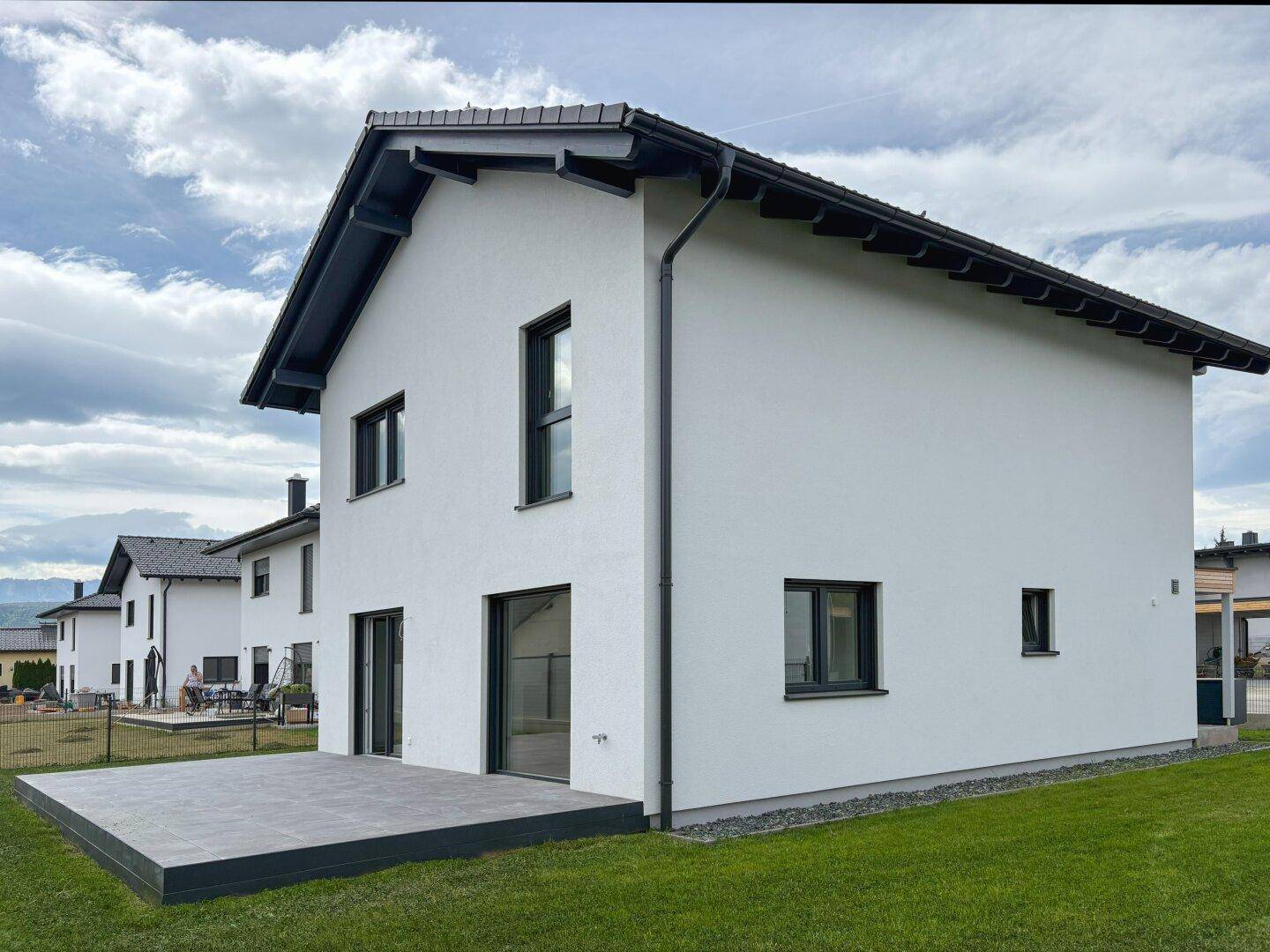 Rückansicht des Hauses mit großer Terrasse und Garten.
