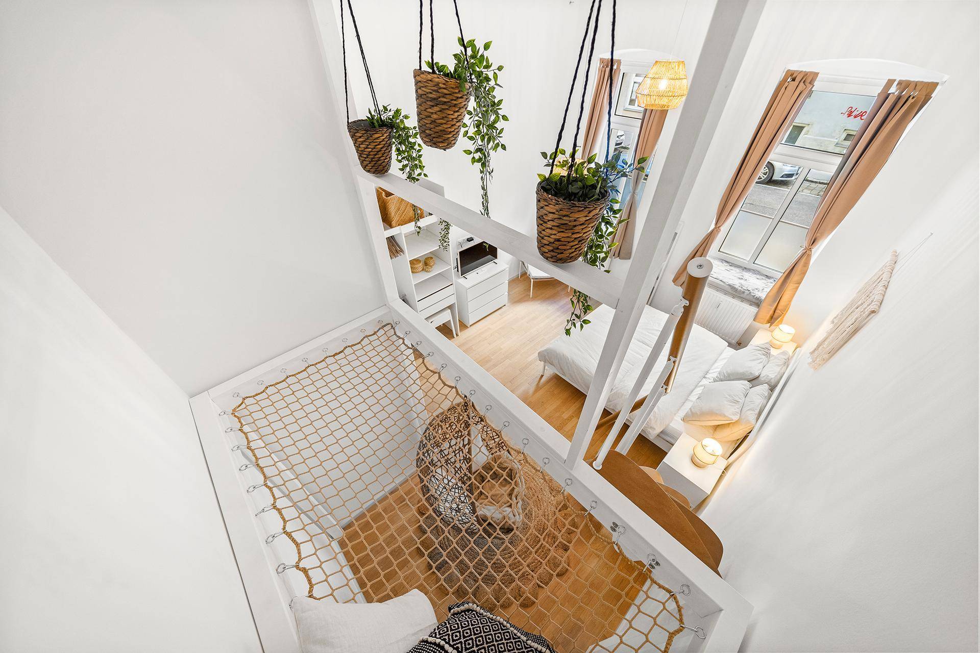 Blick von oben auf das Schlafzimmer mit Hängematte und Pflanzen, im Loft-Stil gestaltet.