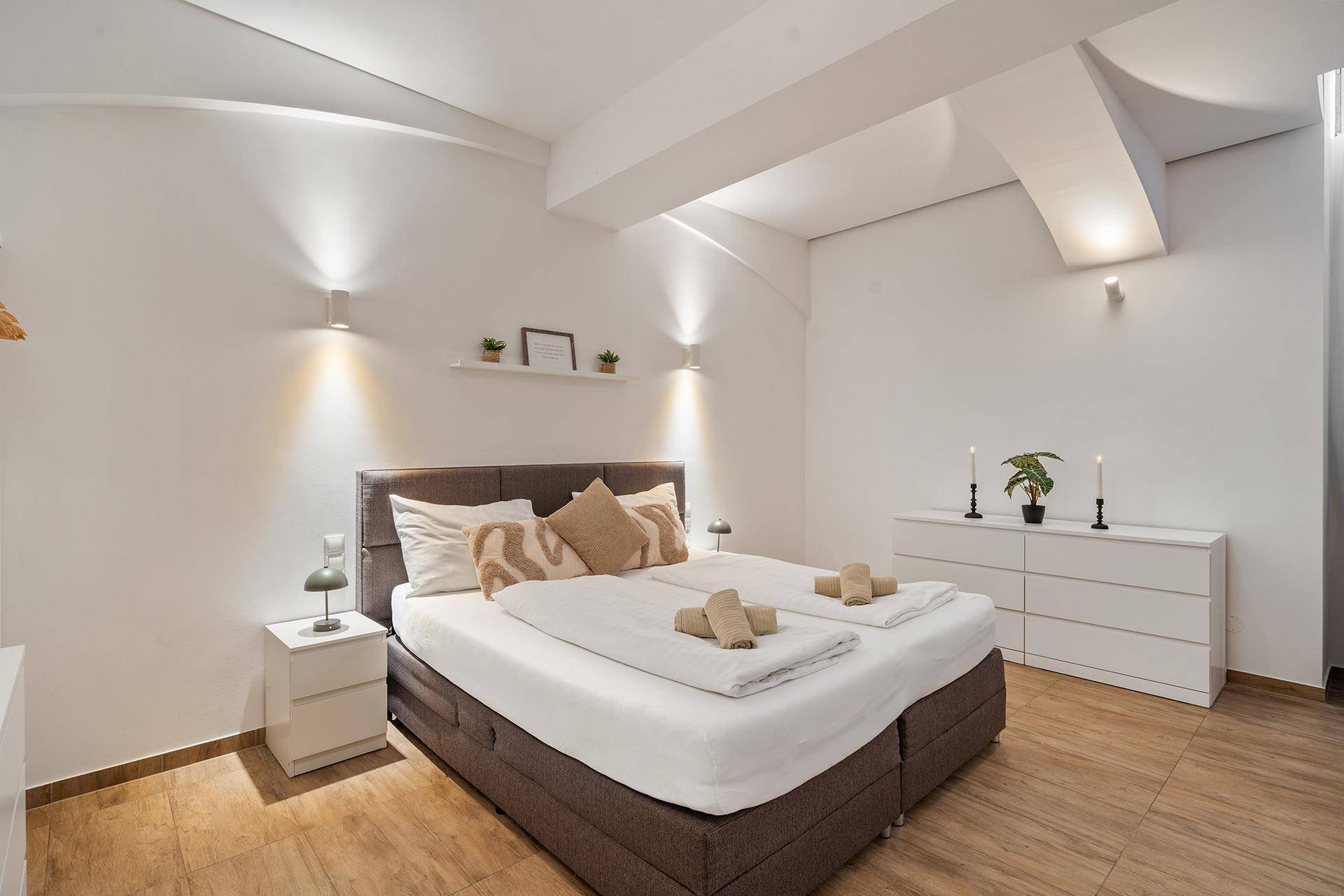 Komfortables Doppelbett in einem hellen Schlafzimmer mit minimalistischer Einrichtung.
