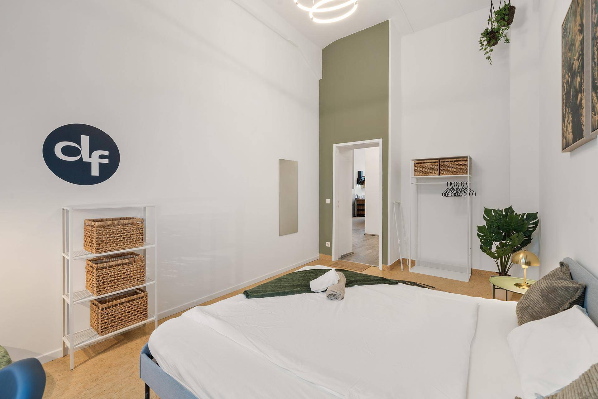 Modern eingerichtetes Schlafzimmer mit hohem Decken und Zugang zu weiteren Räumen.