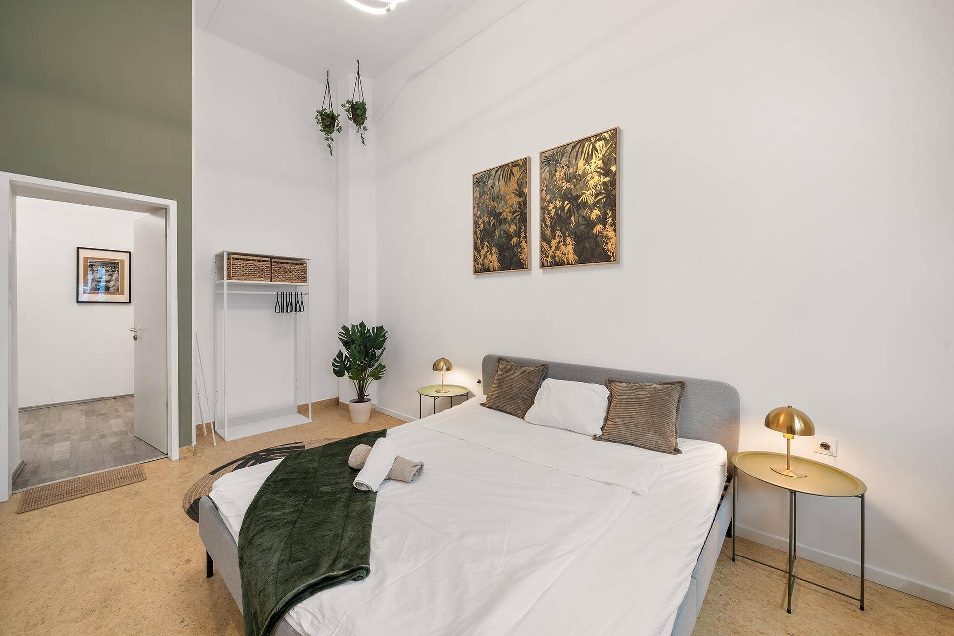 Geräumiges Schlafzimmer mit Doppelbett, Nachttischen und Blick in den Flur.