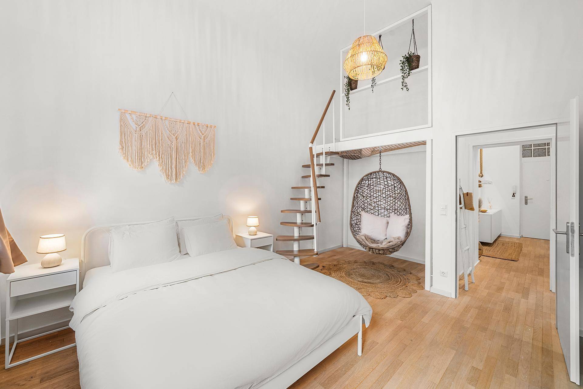 Schlafzimmer mit Hochbett, Hängesessel und Wendeltreppe in einem modernen Loft-Stil.