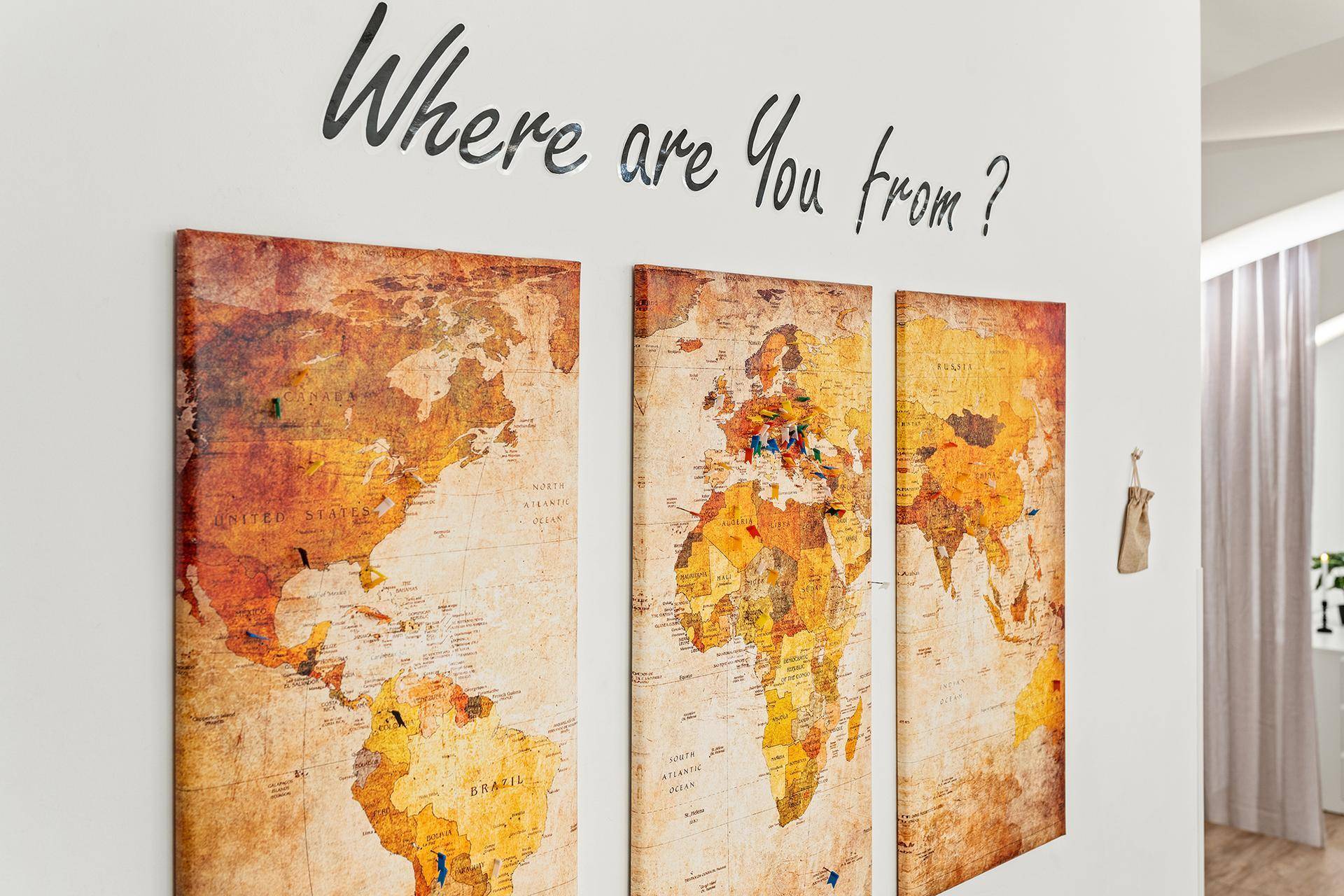 Wanddekoration mit Weltkarten und der Frage "Where are You from?".