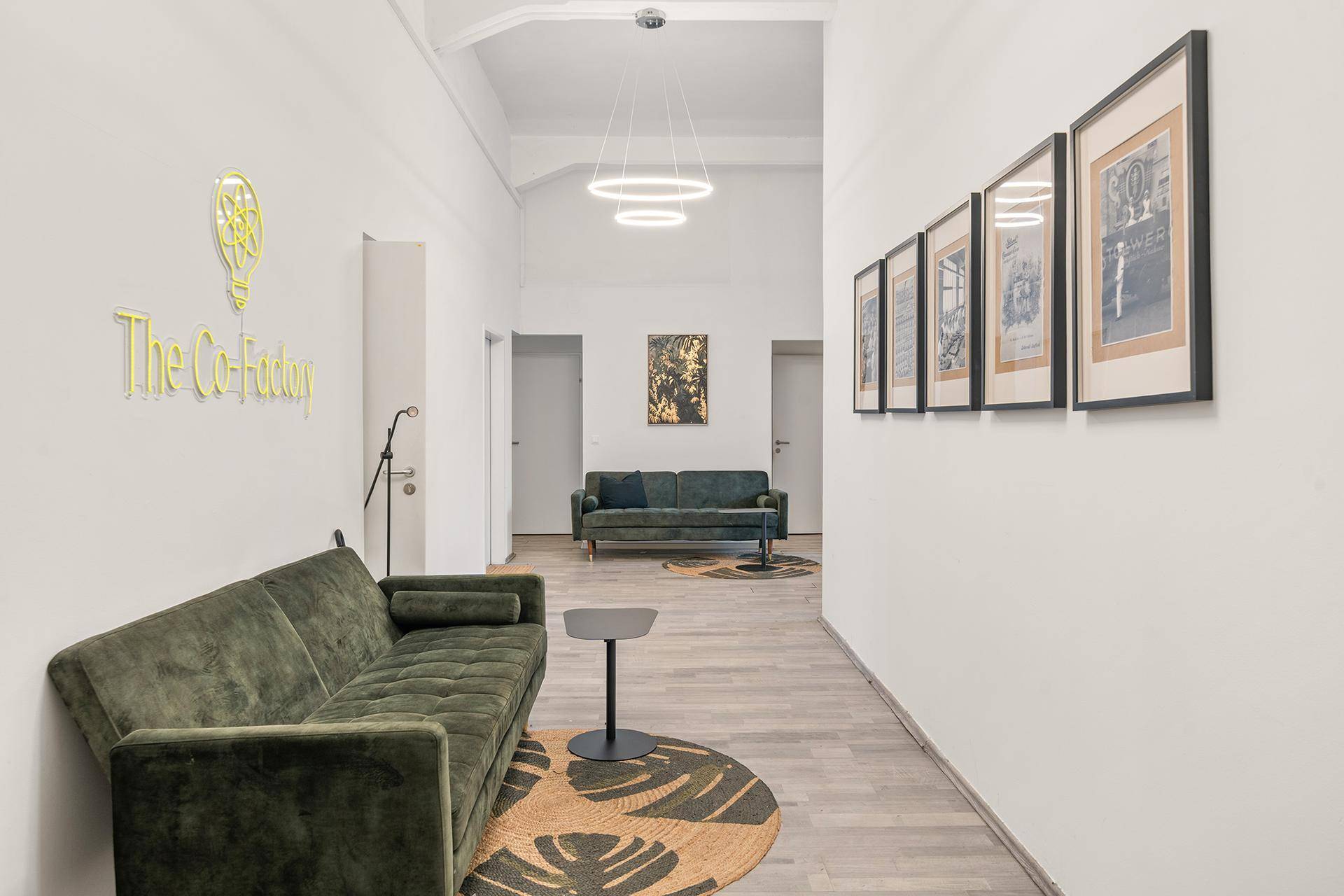 Heller Flur mit bequemen Sofas und moderner Beleuchtung, ideal für Wartebereiche.