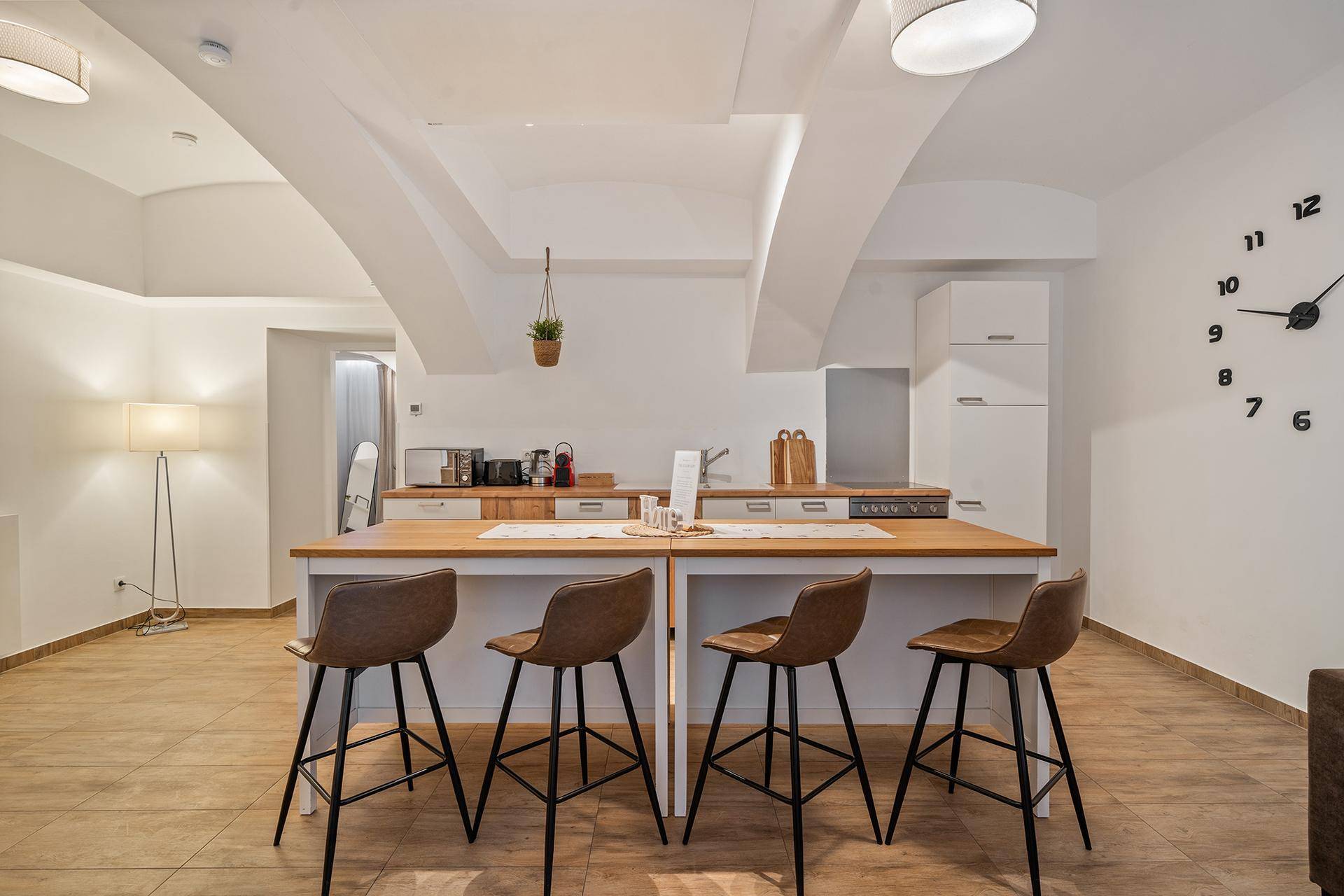 Moderne Küche mit großer Kücheninsel, Barhockern und integrierten Geräten.